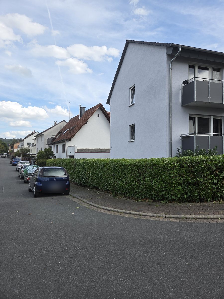 Frisch geschnittene, gerade Kirschlorbeerhecke an einer Hausecke